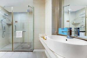 A modern bathroom with a glass-enclosed shower, a large white sink, and a mirror. - Yuheng Hotel Foshan (Foshan)