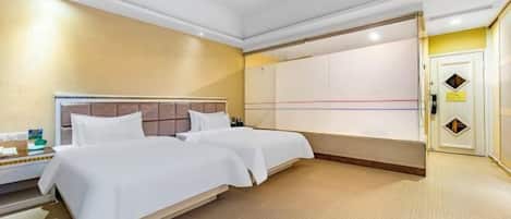 Habitación de hotel con dos camas, un armario y una mesita de noche.