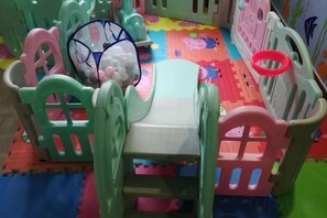 A children's play area with a small table and chairs, a ball pit, and colorful foam mats. - Yuheng Hotel Foshan (Foshan)