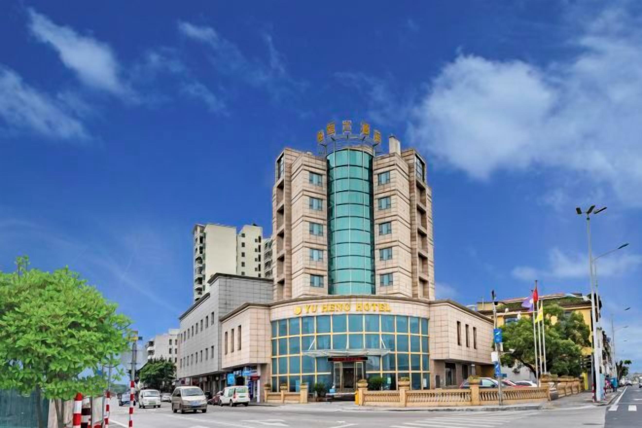 A hotel with a prominent entrance, multiple floors, and a clear sky.