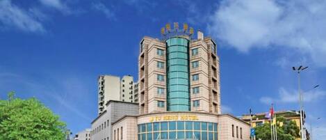 A hotel with a prominent entrance, multiple floors, and a clear sky.