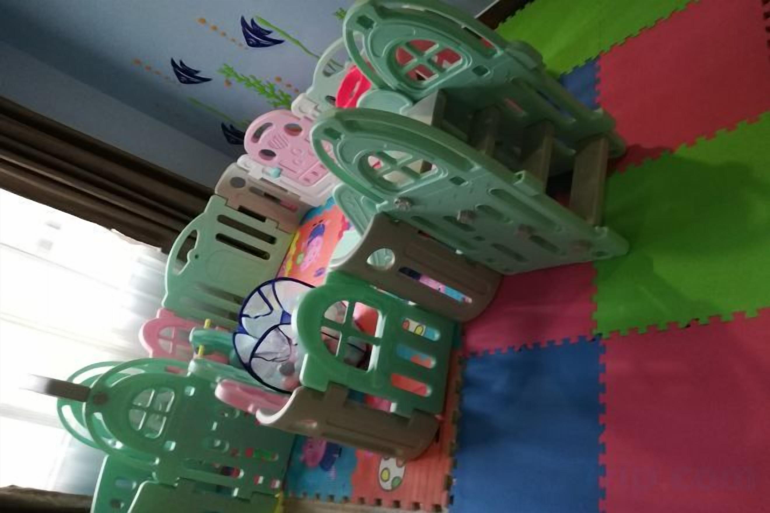Un espace de jeux équipé de tapis de sol en mousse modulaires et d’une structure de jeu.