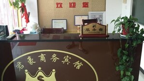 Un comptoir d’accueil avec une pancarte indiquant un centre d’affaires et un espace de réception.