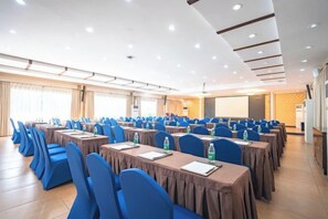 A conference room with rows of tables and chairs, equipped with water bottles and notepads. - Dongshan Pearl Island Hotel (Shenzhen)
