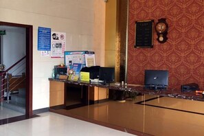 A reception area with a desk, a computer, and a wall clock.