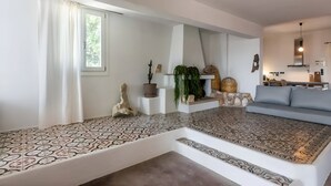 Un salon moderne avec un sol à motifs, un canapé, un coin repas et une cuisine en arrière-plan.