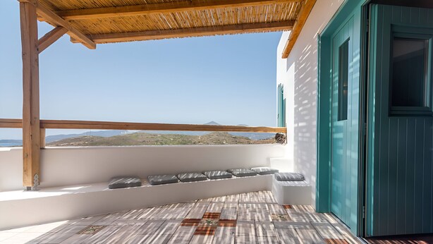 Un balcon doté d’un sol à motifs, d’une pergola en bois et offrant une vue sur la mer.