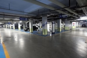 A multi-level parking garage with clear directional signage, multiple parking spaces, and structural pillars. - Shanghaojia Apartment (Zhengzhou Digital Harbor) (Zhengzhou)