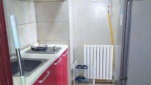 A kitchen with a sink, a refrigerator, and a white radiator. - Shanghaojia Apartment (Zhengzhou Digital Harbor) (Zhengzhou)