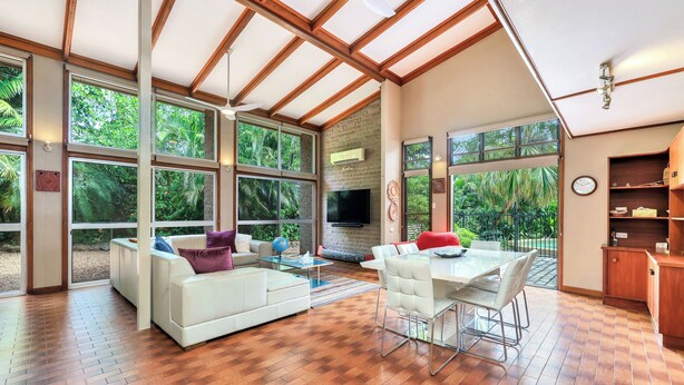 A spacious living area with a large TV, comfortable seating, and a dining table. - Tropical Crush | 4 Beds, 2 Bath | Pool (Fannie Bay)