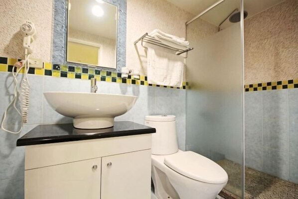 A bathroom with a sink, toilet, and shower. - Tansui micasa inn (New Taipei City)