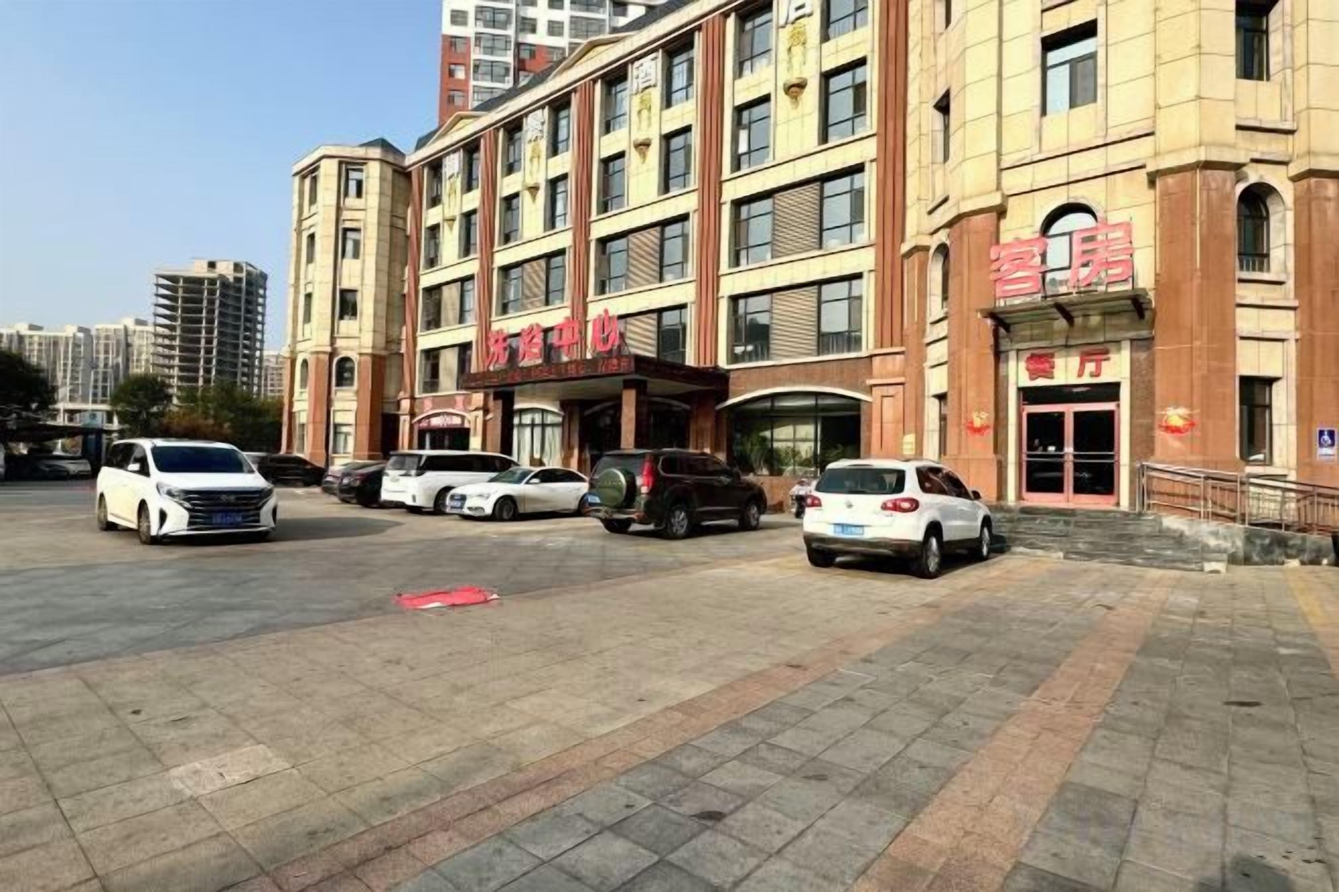 A multi-story hotel with a parking lot in front.