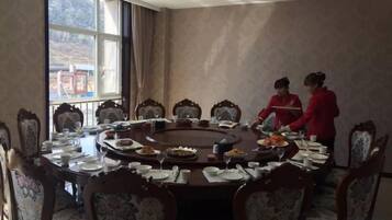 A conference room with a round table, chairs, and a window.