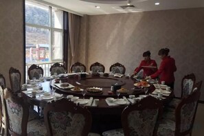 Une salle de conférence avec une table ronde, des chaises et une fenêtre.