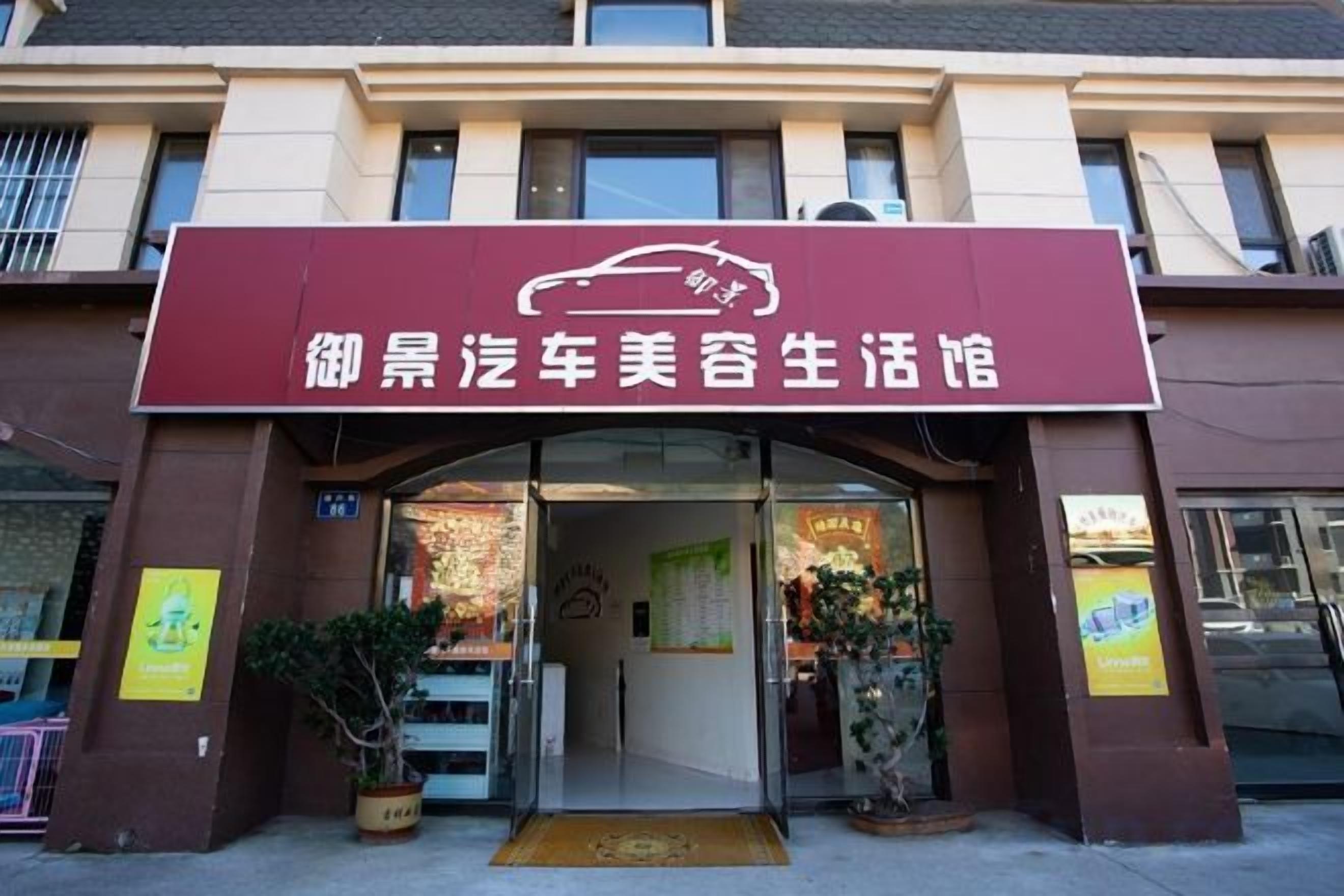 A building with a sign that reads '御景汽车美容生活馆' and a doorway leading into the establishment.