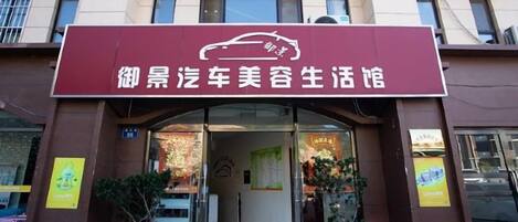 A building with a sign that reads '御景汽车美容生活馆' and a doorway leading into the establishment.