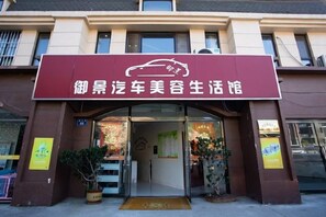 Edifici amb un rètol que diu '御景汽车美容生活馆' i una entrada cap a l'establiment.