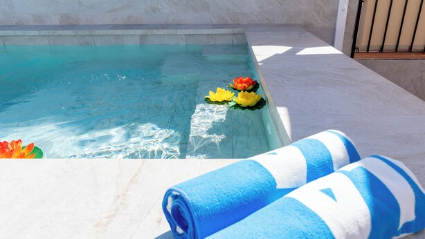 A swimming pool with water lilies and blue towels on the edge. - Corazón de Triana. Terrace & private pool (Sevilla)