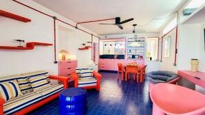 A modern interior with a sofa, chairs, a dining table, and a kitchen area. - Villa Bel in La Maddalena (La Maddalena)
