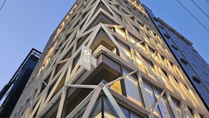 A modern building with a geometric facade and illuminated windows. - UH Suite The Gangnam (Seoul)
