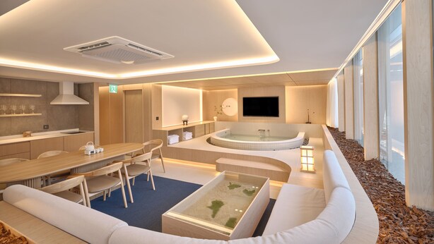 A modern hotel room with a kitchen area, a seating area with a small pool, and large windows providing a view. - UH Suite The Gangnam (Seoul)
