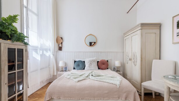 A bedroom with a bed, bedside tables, a wardrobe, and a chair.
