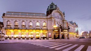 A historic building with ornate architecture, large windows, and a prominent dome.