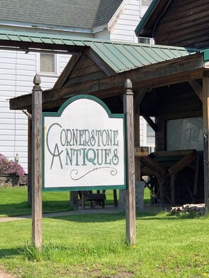 A sign for Cornerstone Antiques in front of a building with a green roof. - Catskill Retreat (Hamden)