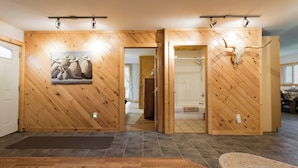 Ein Zimmer mit Holzwänden, einer großen Holztür, Holzboden und einem Teppich.