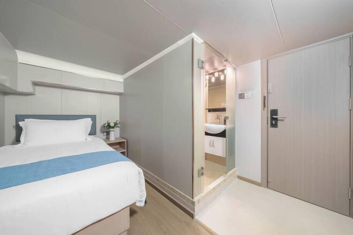Un dormitorio con cama, mesita de noche y vestidor.