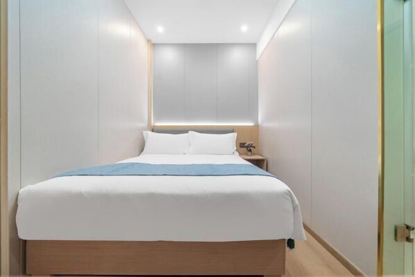 A modern hotel room with a large bed, a bedside table, and a nightstand. - Yipin Business Travel Hotel (Xiamen Zhongshan Road Pedestrian Street) (Xiamen)