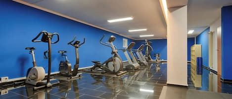A gym with exercise equipment and a blue wall.