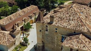 Ein historisches Steinhaus mit Innenhof, Schwimmbad und umliegenden Feldern.