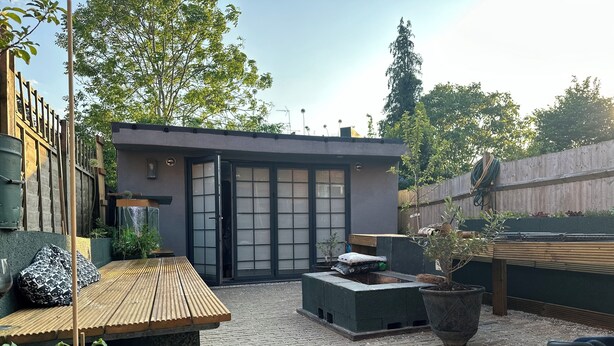 A courtyard with a wooden bench, a small table, and a potted plant. - Inviting 1-bed Studio in London (London)