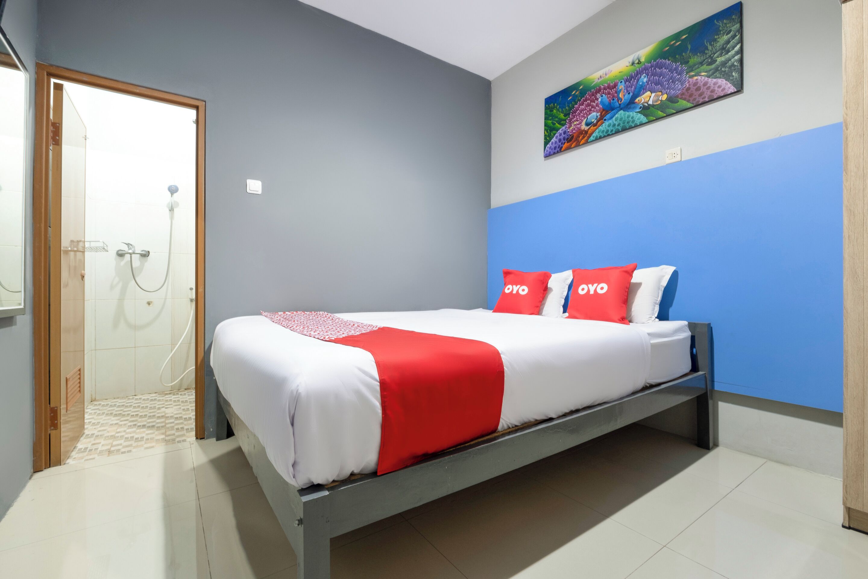 A bedroom with a bed, a shower, and a painting on the wall.