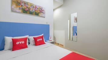 Una habitación de hotel con cama, mesita de noche, un cuadro y un espejo.