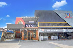 Ein Hotel mit einem gut sichtbaren 'OYO'-Schild, einem 'SYARIAH PARIS'-Schild und einem '#ADAAntukAnda'-Banner.