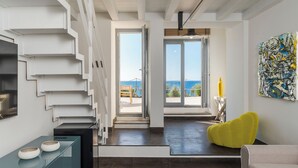 A modern interior with a staircase, a dining area, and a view to the outside. - Tower of the 7 friars - Tower in Cefalu with direct access to the beach (Cefalù)