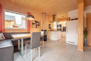 Cozy cabin with a warm atmosphere, comfortable sofa, and dining table, perfect for relaxation and meals.