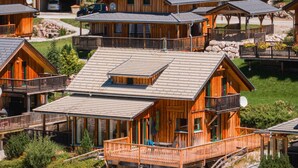 A wooden lodge with multiple cabins, each featuring balconies and a central building with a flat roof.