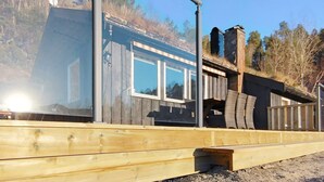 A wooden cabin with a large window, a metal railing, and a satellite dish. - 5 Person Holiday Home in Oydegard (Tingvoll)