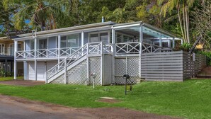 A two-story house with a covered porch, a fenced yard, and a garage. - Yaringaa by HolidayCo. (HARDYS BAY)