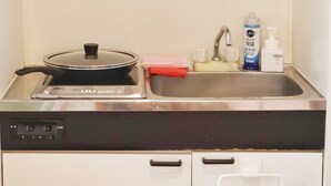 Une cuisine équipée d’une cuisinière, d’un évier et de divers ustensiles de cuisine.