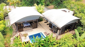 A modern villa with two separate living areas, a swimming pool, and lush greenery surrounding the property. - 5 min to beach-private pool-great for couples (Dominicalito)