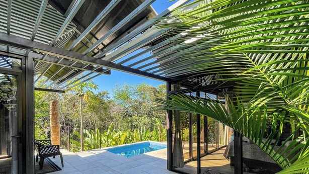 A covered outdoor area with a pool, seating, and tropical plants. - 5 min to beach-private pool-great for couples (Dominicalito)