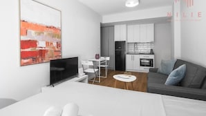 A modern apartment with a living room, dining area, and kitchen. - Arama Nilie Hospitality MGMT (Thessaloniki)