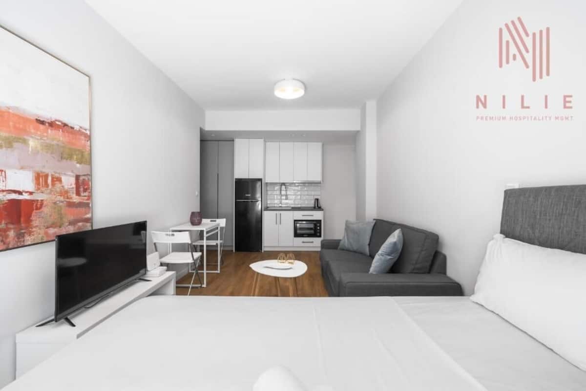 A modern apartment with a living room, dining area, and kitchenette.