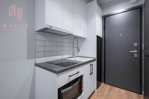 Studio, balkon | Privékeuken | Een koelkast met diepvriezer, een microgolfoven, een waterkoker