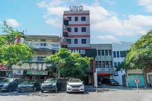 A hotel with a prominent 'UNO' sign, multiple floors, and parked cars in front. - Hotel O Genteng Near Genteng Market Formerly Uno Hotel (Surabaya)