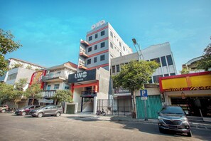 A hotel with a modern design, a visible entrance, and a parking area. - Hotel O Genteng Near Genteng Market Formerly Uno Hotel (Surabaya)